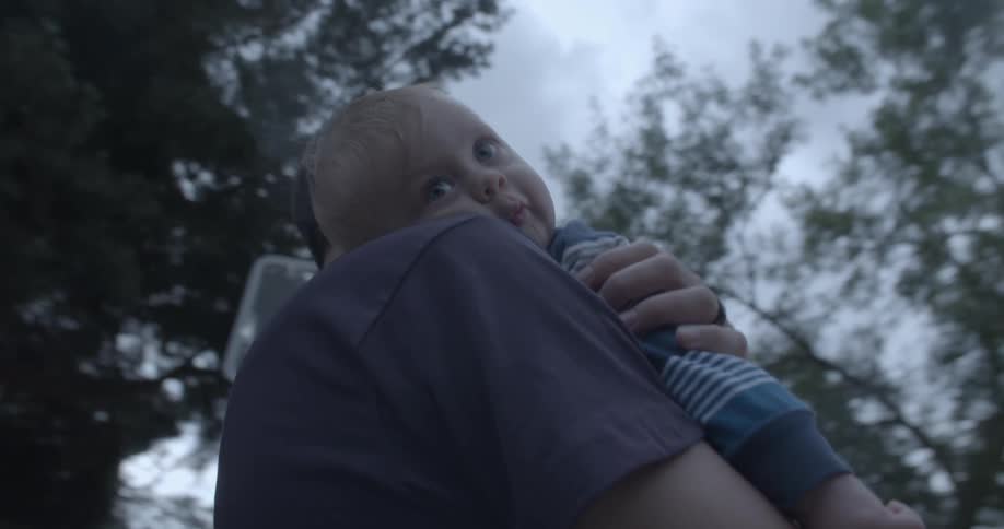 Father hugging his son outdoors surrounded by trees