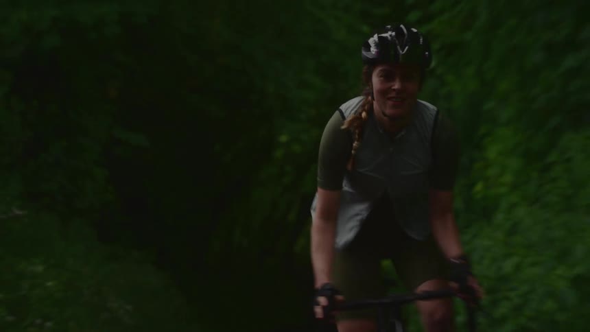 Cyclist riding along a trail surrounded by trees