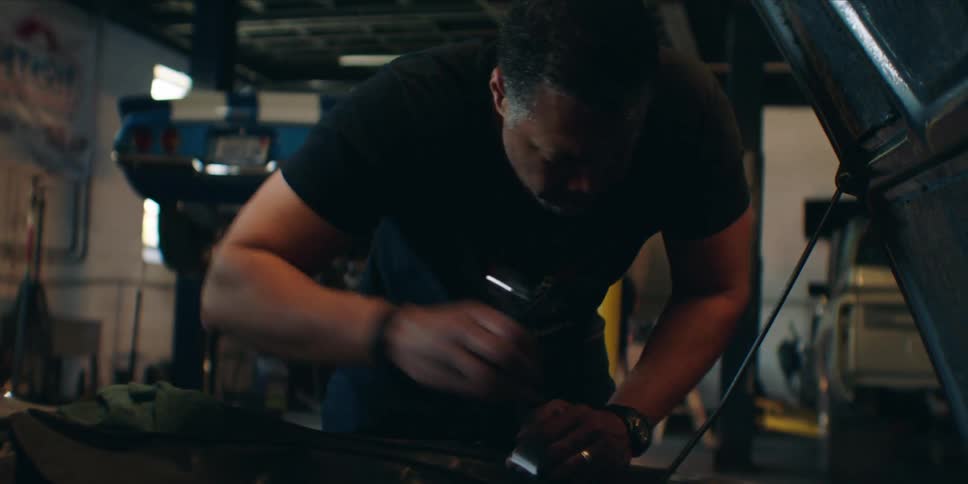 Mechanic working on a vehicle engine in a workshop