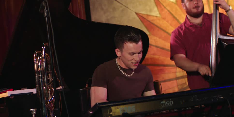 Two people play musical instruments during a live stage performance