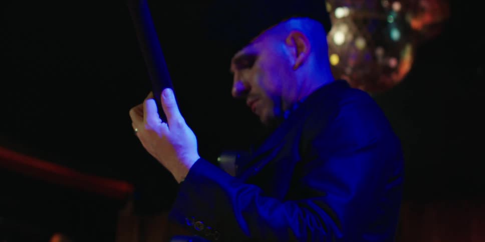 A musician performing on stage at a concert passionately playing a guitar under bright stage lights