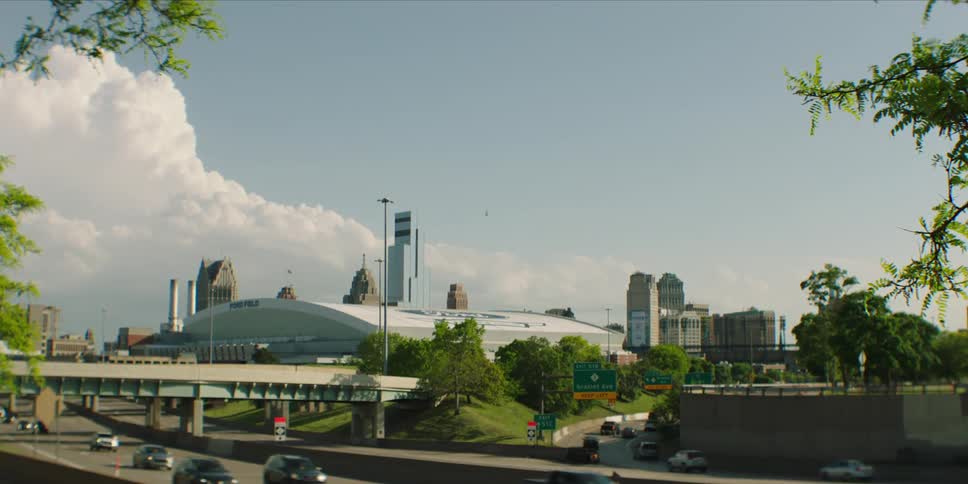 City skyline with ford field and busy freeway under clear skies