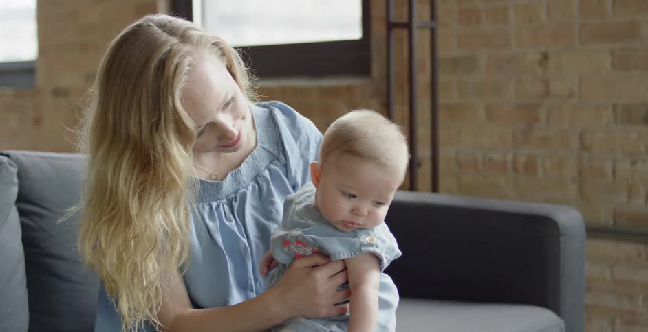 A baby is sitting on a woman's lap