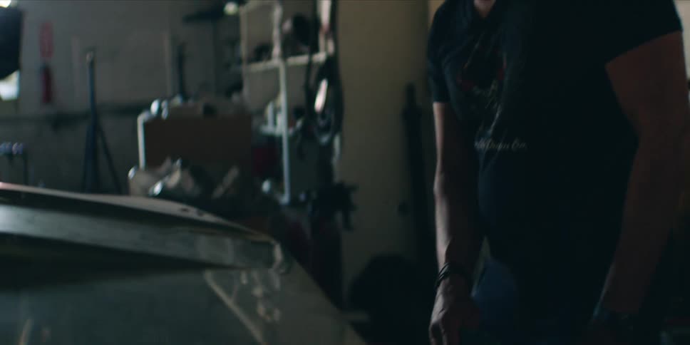 The mechanic is smiling down on a car