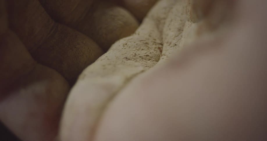 A man holds a beige powder in his hand