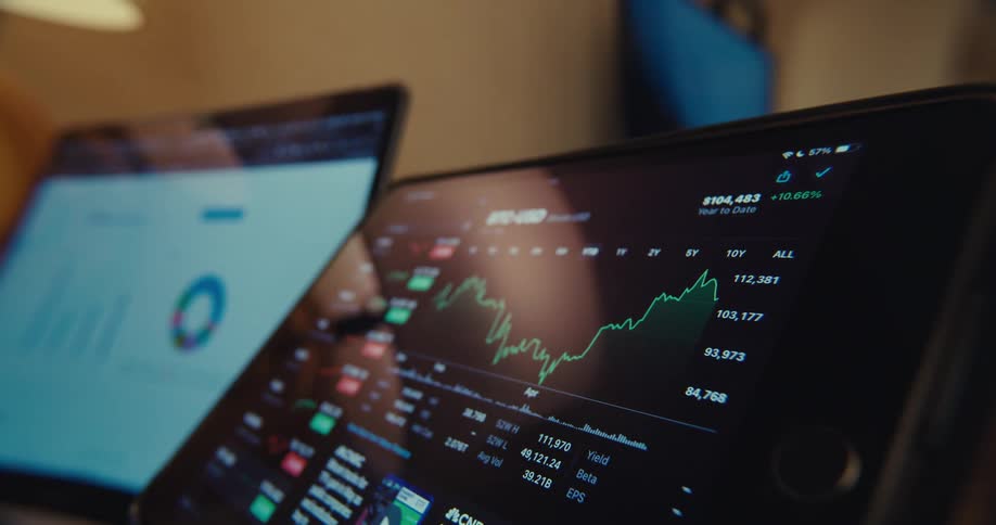 Two computers display plots and graphs relevant to stock information