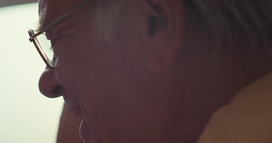 Close up of an elderly man looking and gesturing towards a tablet with a replaceable screen