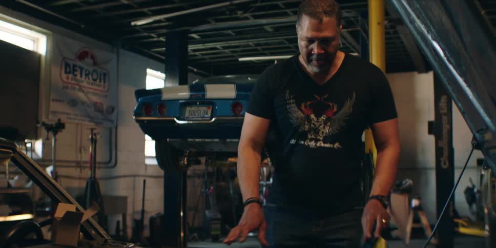 A man repairs a vehicle inside a car garage