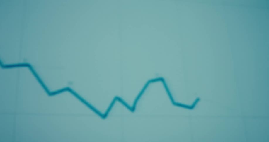 A blurry stock line graph slopes downward against a blue background