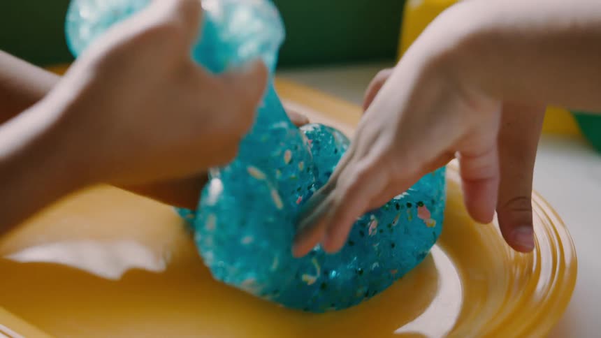Two children fold and play with slime