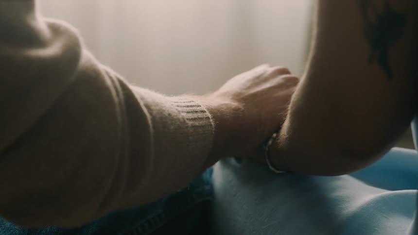 Two people hold hands