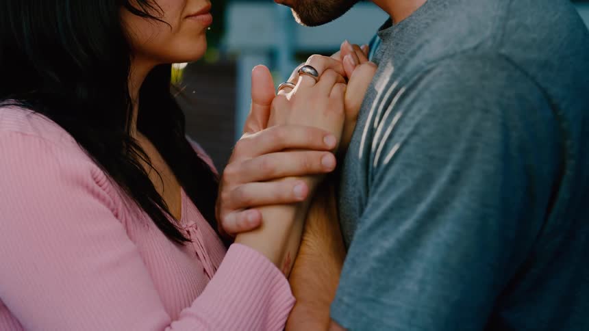 A couple hold hands while dancing outside