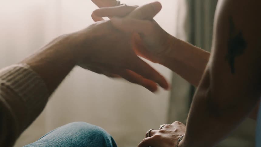 Close up of a couples hands as they perform and practise their special handshake