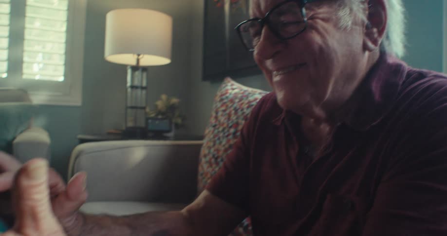 A man smiles while typing on his cell phone