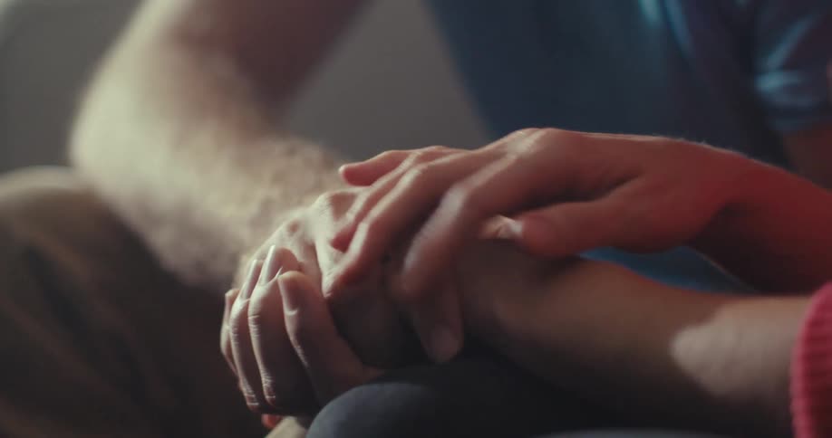 Close up of a couple holding and caressing their hands