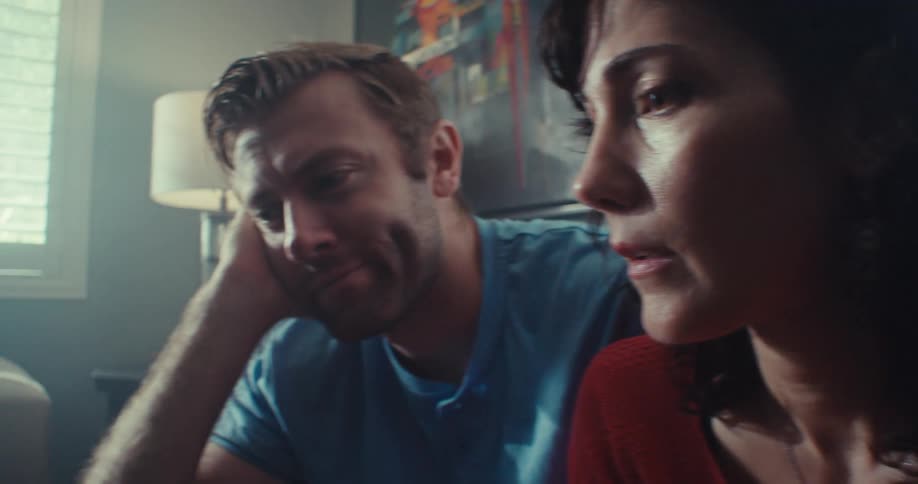 Couple sits in their living room and talks during the daytime