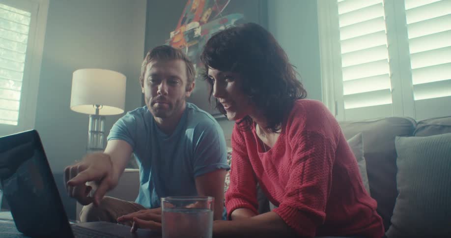 Friends have a discussion while looking at a laptop
