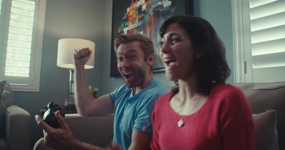 A happy couple highfives indoors after winning a video game excited and smiling