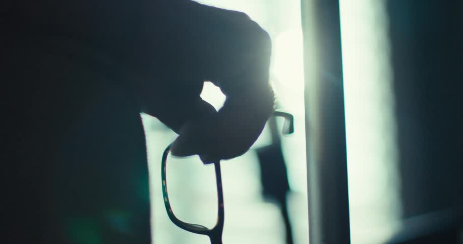 Silhouette of a hand holding glasses
