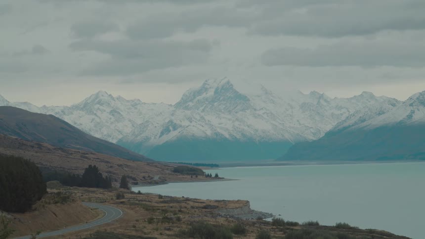 Snow covered mountains are past the lake