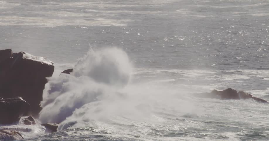 Large waves crash against the rocks