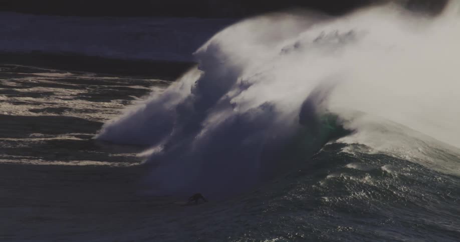 A surfer rides the giant wave by the shore