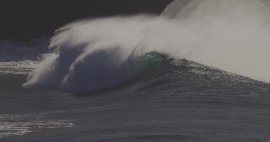 The surfer rides high on the large wave