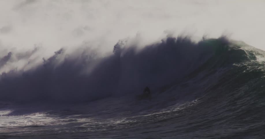The surfers ride large waves together