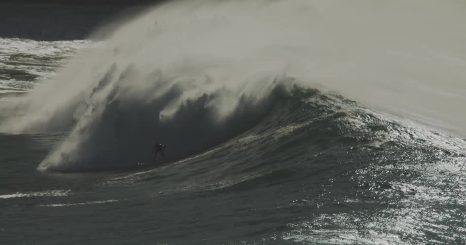 The surfer is riding the wave to the shore