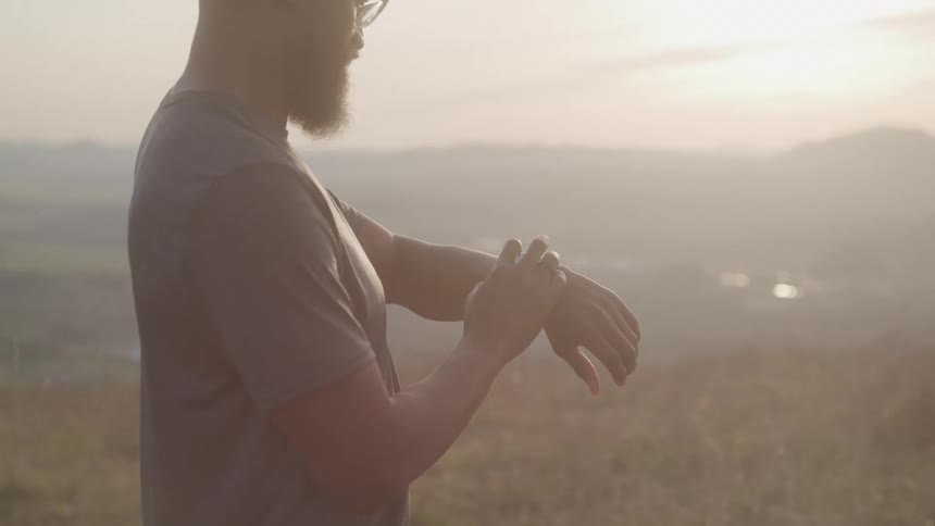A man is checking his watch on a foggy day