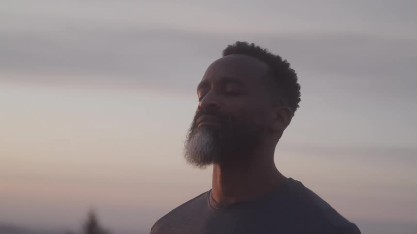 Man outdoors with eyes closed