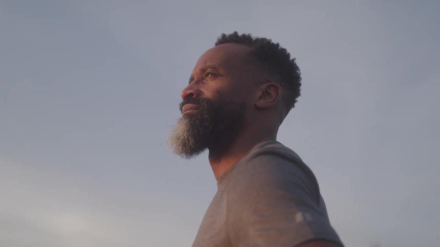 A man is looking up at the cloudy sky