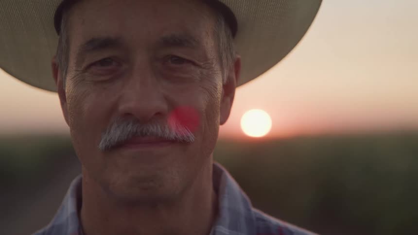 The sun is rising behind the man