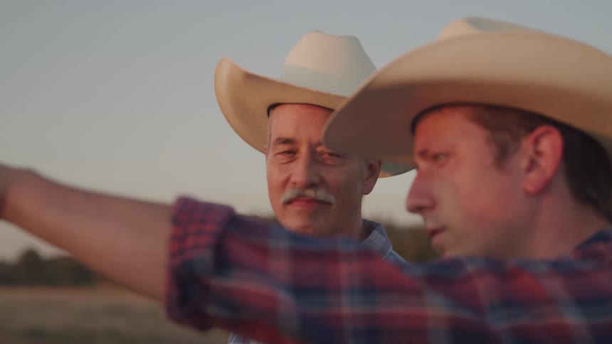 Two farmers are talking and pointing