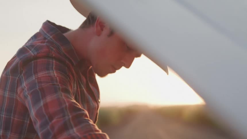 A man is looking down at his vehicle