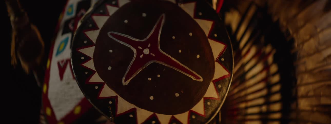 Closeup of native american regalia with a painted shield beadwork and feathers