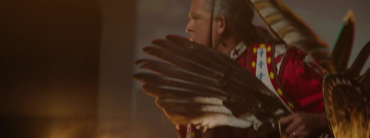 A man is waving a scepter and dancing in a costume