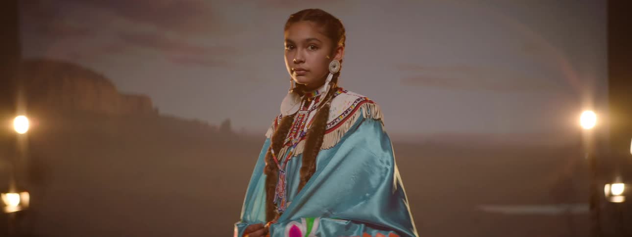 A native american teenage girl wearing traditional indigenous clothing in a photo studio