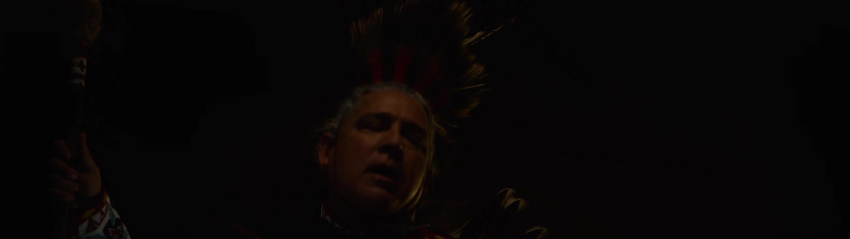 A man waves his scepter as he dances