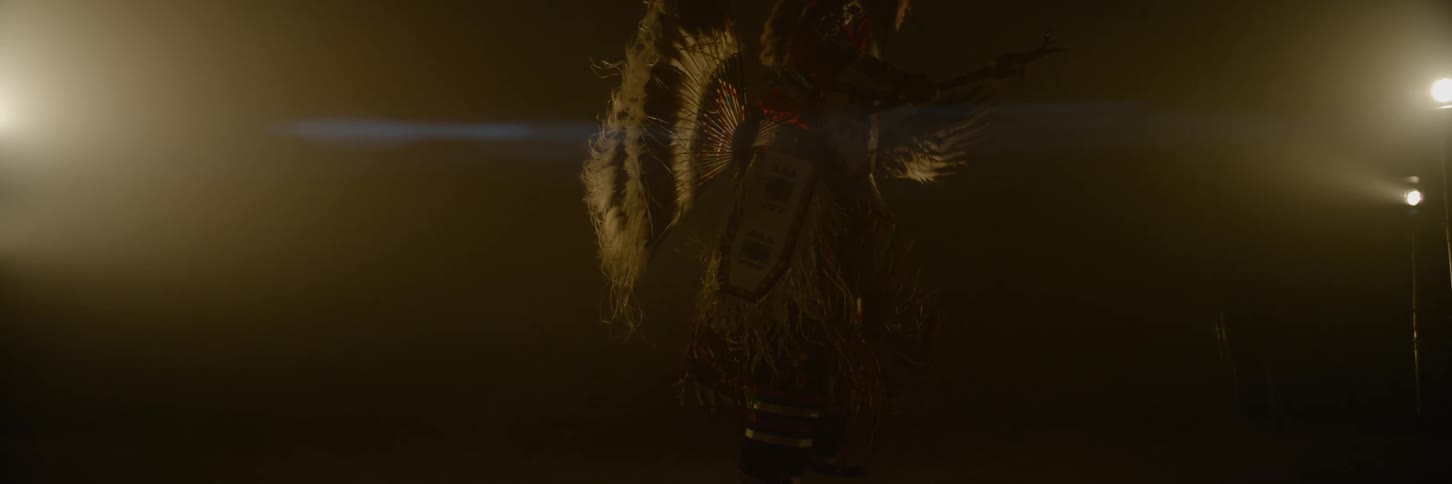 The man is dancing in a colorful costume