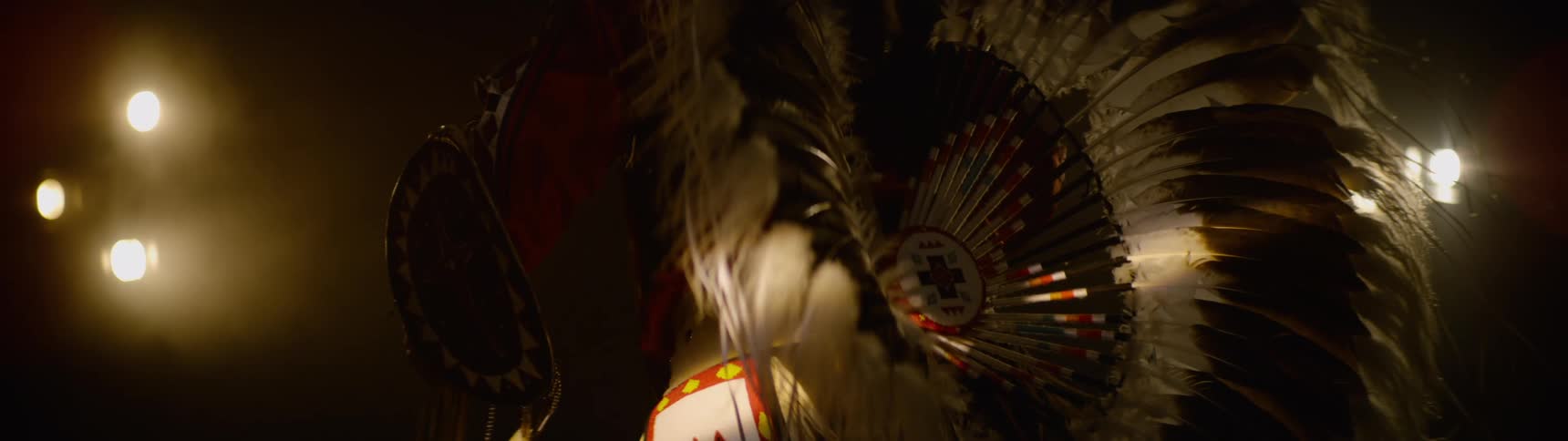 Native american dancer wears ceremonial attire while dancing