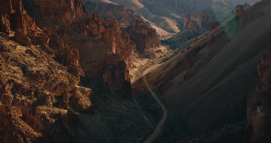 Aerial view of a mountain range with a small road going through the center