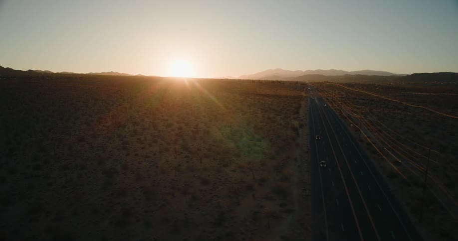 The sun is rising on the desert road