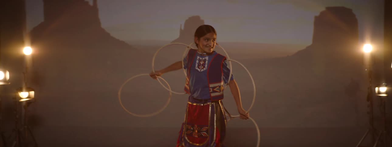 A girl is dancing on stage with five hoops