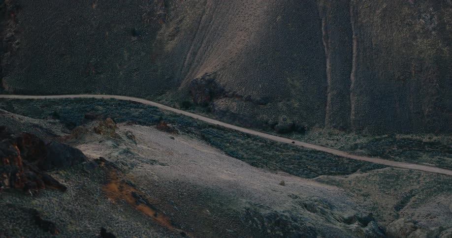 A motorcycle is riding on a trail by the mountains