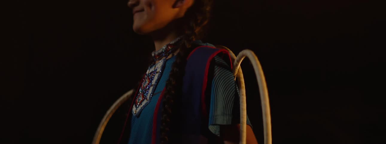 A girl is wearing a costume and holding hoops