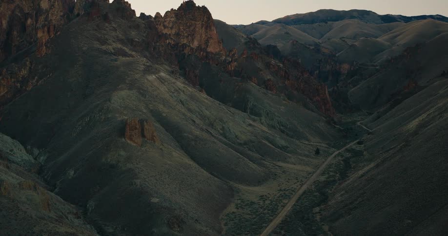 Aerial view of a canyon road through the mountains in the desert at sunset