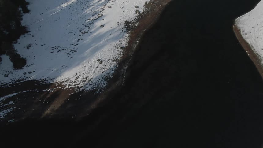 Lake in a snowy area with conifers around it