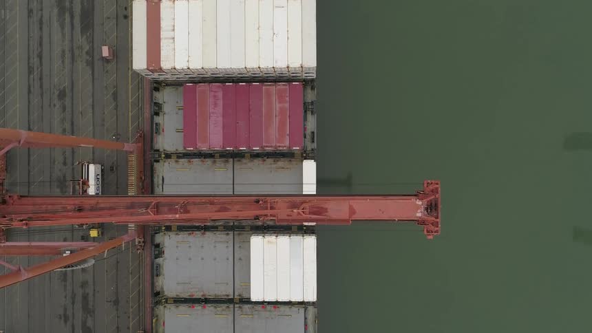 A crane hovers over cargo at the docks