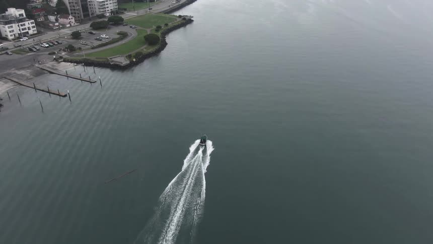 Aerial view of a boat traveling by sea near a city